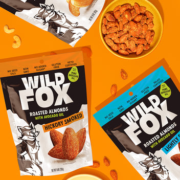 Wild Fox roasted almonds packaging and bowl of almonds on an orange background
