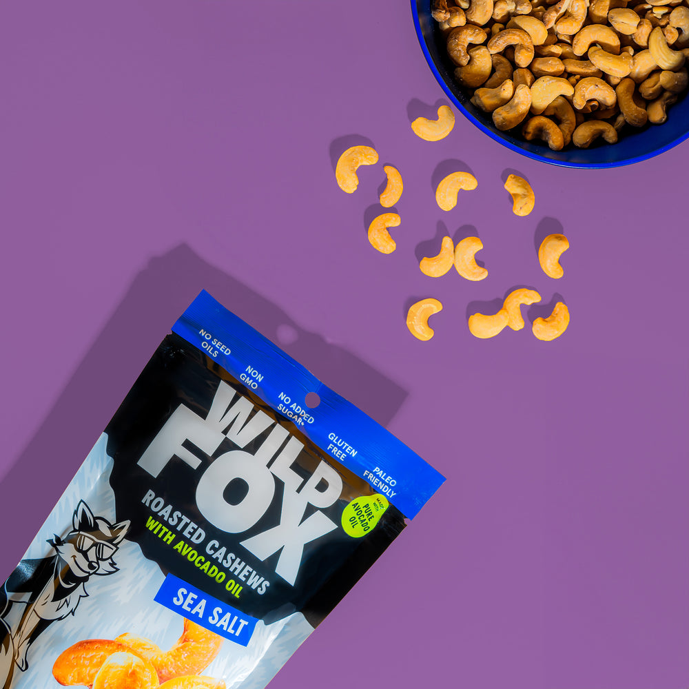 Wild Fox Sea Salt Roasted Cashews packaging with cashews on a purple background